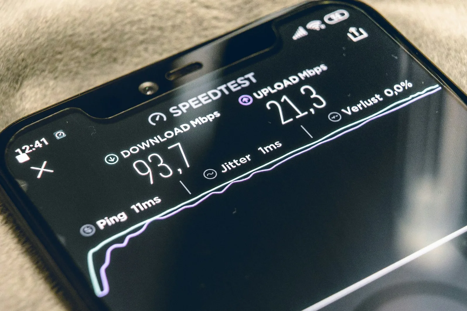 Prikaz aplikacije za testiranje brzine interneta na mobilnom telefonu, koja pokazuje brzinu preuzimanja od 93.7 Mbps i brzinu postavljanja od 21.3 Mbps.