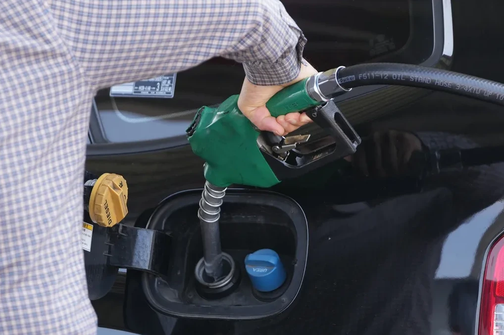 Čovjek toči dizel u svoj automobil.