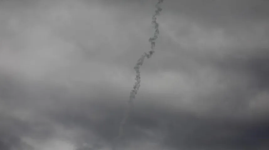 Dimni trag na tamnom, oblačnom nebu