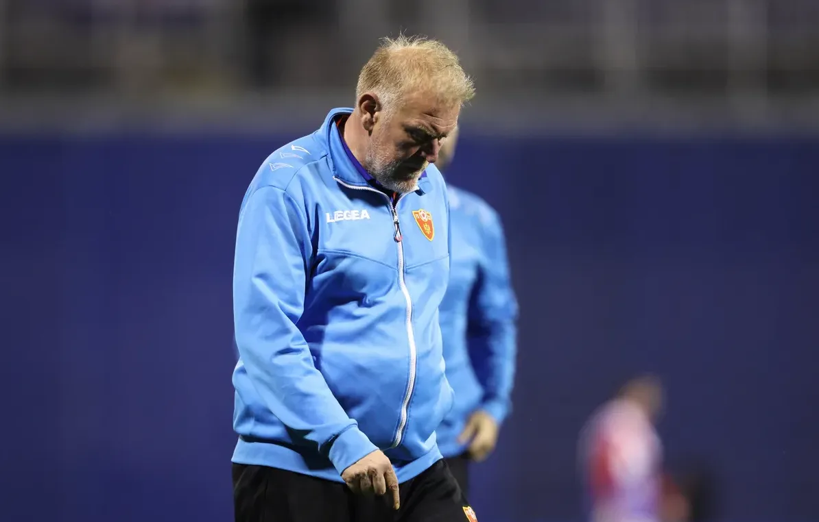 Fudbalski trener u plavoj jakni sa amblemom kluba