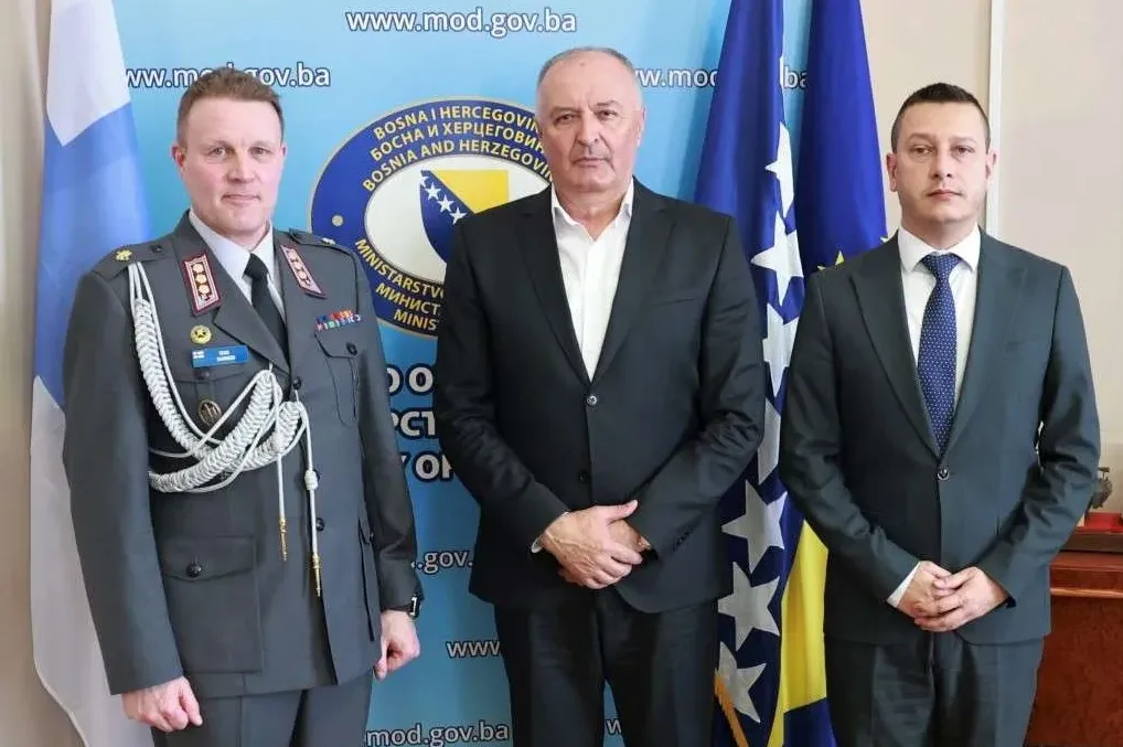 Tri muškarca poziraju ispred zastava Bosne i Hercegovine i Finske.