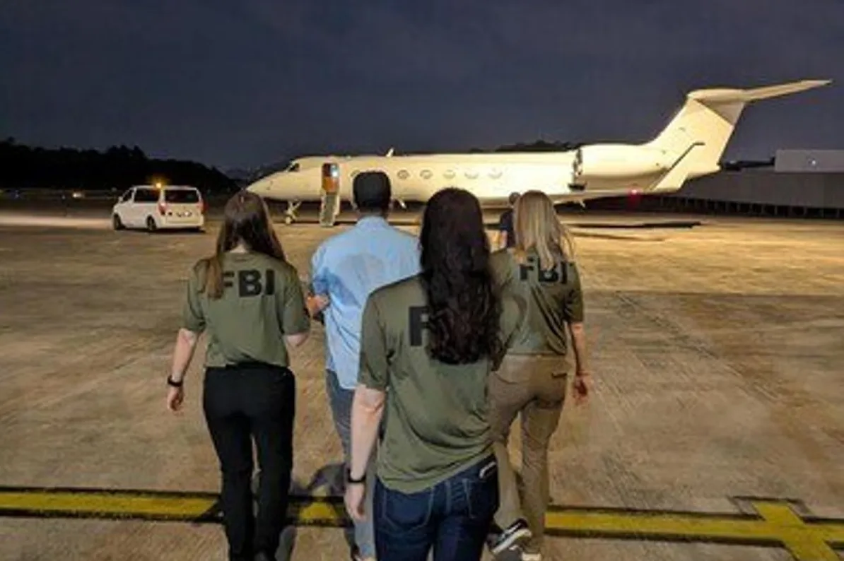 Tri agentice FBI prate uhapšenog muškarca prema avionu na aerodromu.