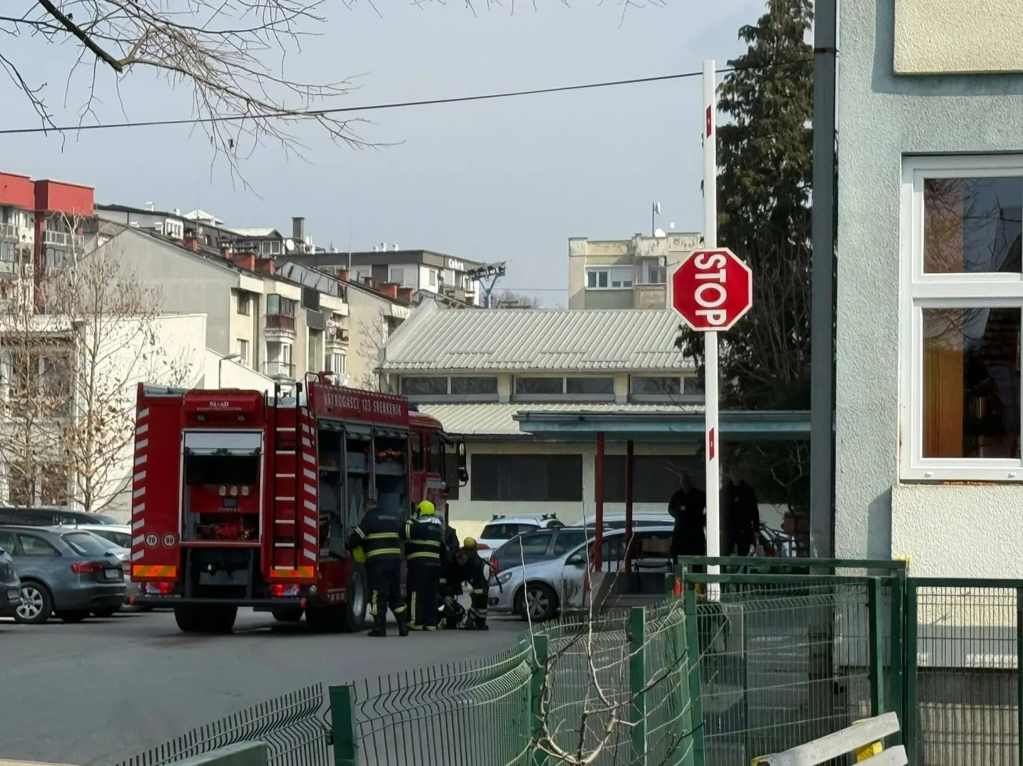 Vatrogasno vozilo i ekipa vatrogasaca na intervenciji pored automobila