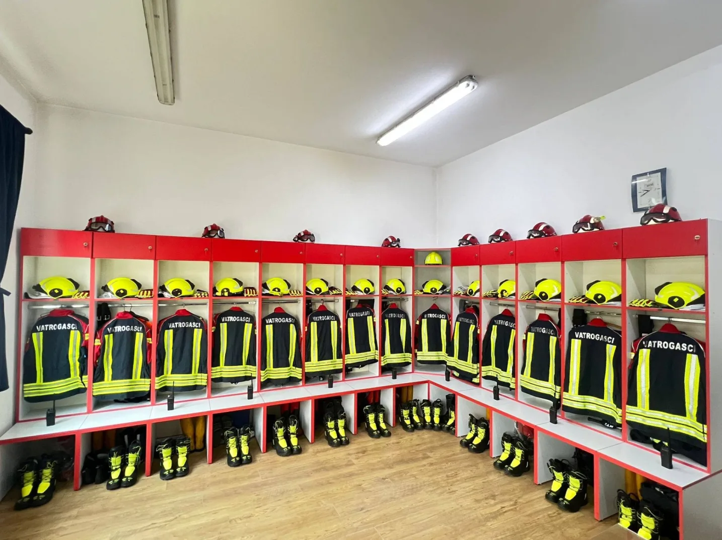 Vatrogasne uniforme i kacige uredno složene u ormarićima.