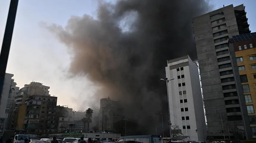 Gusta crna dimna zavjesa diže se visoko iznad gusto naseljenog gradskog područja, zasjenjujući obližnje stambene i poslovne zgrade.