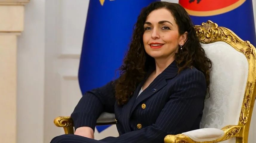 Vjosa Osmani, predsjednica Kosova, sjedi u raskošnoj zlatnoj fotelji, odjevena u tamni prugasti sako.
