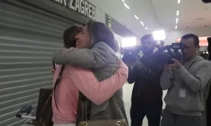 Dvije žene se grle ispred natpisa "ZAGREB" uz prisustvo kamermana.