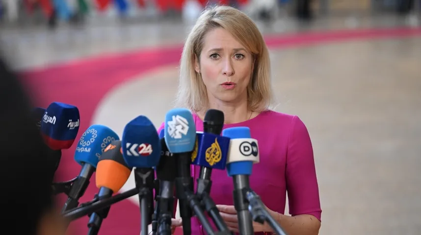 Žena u ružičastoj haljini govori u brojne mikrofone medijskih kuća ispred sebe.