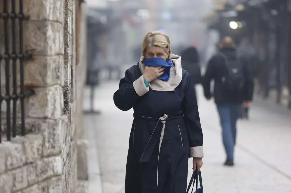Žena s plavom maramom pokrivenog lica hoda ulicom