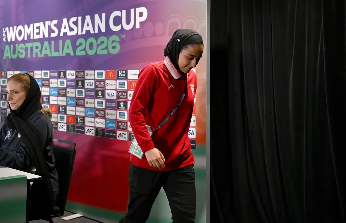 Fudbalerka u crvenom dresu sa hidžabom na glavi ulazi na pres konferenciju za Žensko azijsko prvenstvo u fudbalu 2026. u Australiji.
