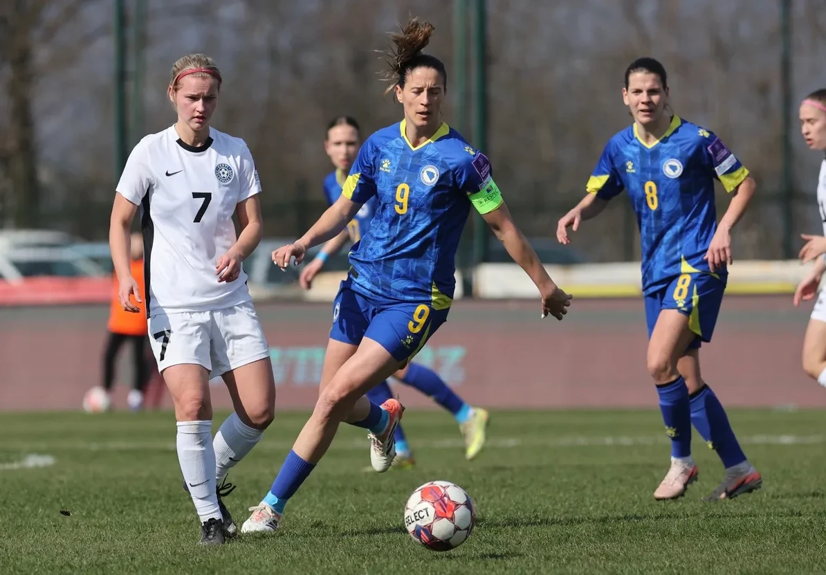 Fudbalerka Bosne i Hercegovine u plavom dresu sa brojem 9 kako vodi loptu u nogometnoj utakmici protiv Estonije.