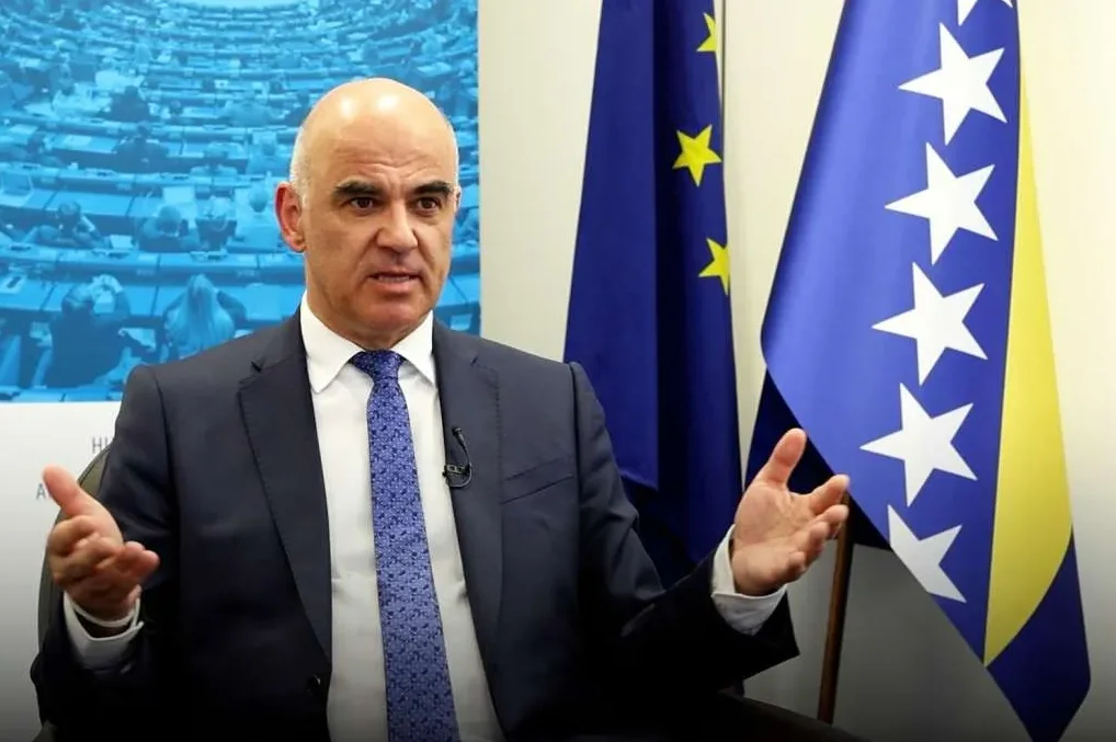 Alain Berset, švajcarski predsjednik, sjedi sa zastavom Evropske unije i zastavom Bosne i Hercegovine iza njega.