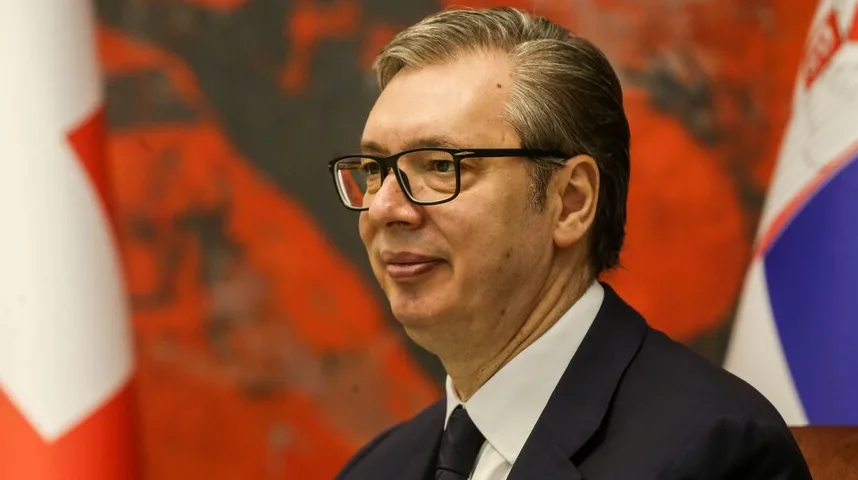 Aleksandar Vučić u tamnom odijelu i sa crnim naočarima, gleda blago lijevo od kamere.