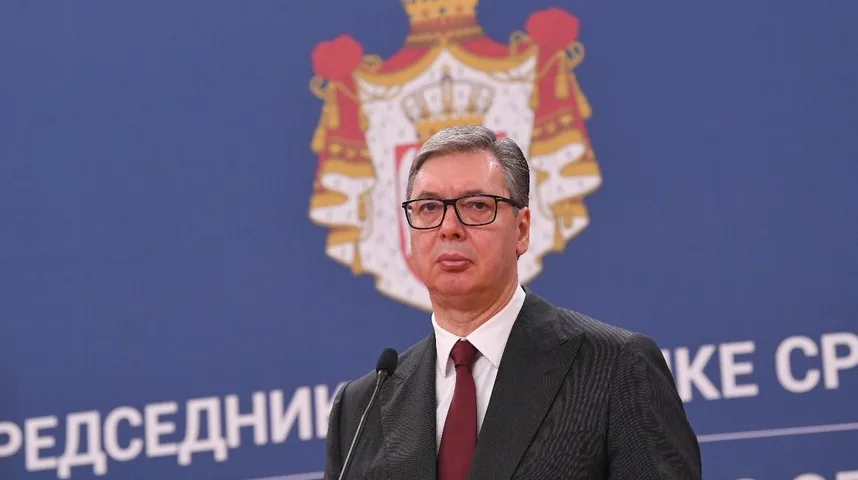 Portret Aleksandra Vučića, Predsjednika Republike Srbije, koji stoji ispred grba Srbije i natpisa "PREDSJEDNIŠTVO SRBIJE".