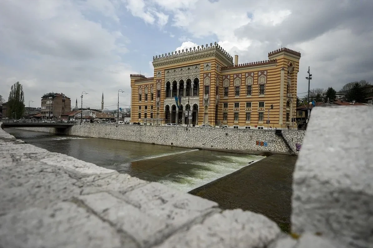 Pogled na prelijepu zgradu Vijećnice u Sarajevu sa Miljackom u prvom planu.