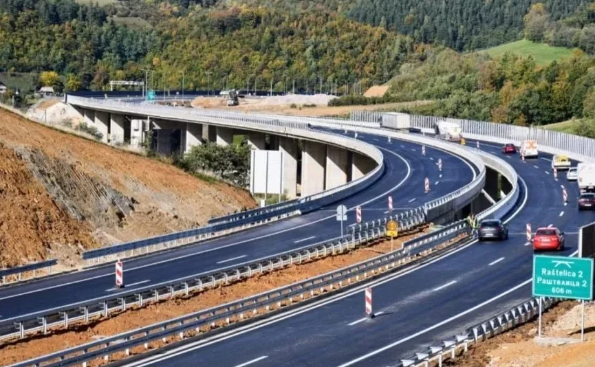 Moderni autoput sa vijaduktom i saobraćajnim znakovima u brdovitom predjelu