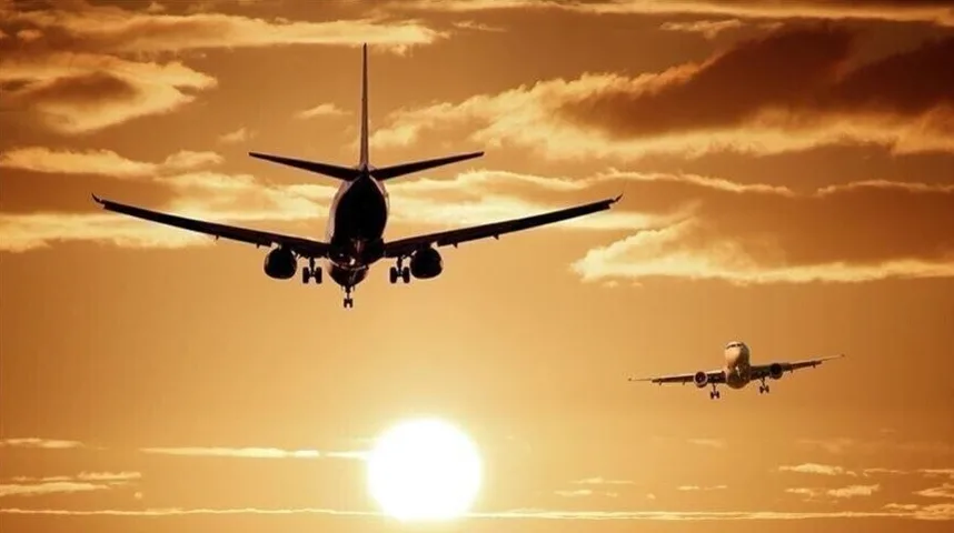 Dva aviona lete u nebo tokom zalaska sunca.