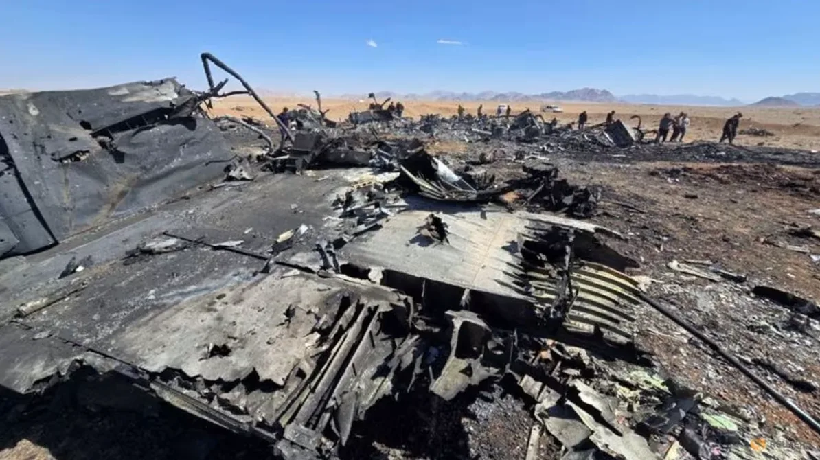 Ostaci uništenog aviona na pustom terenu.