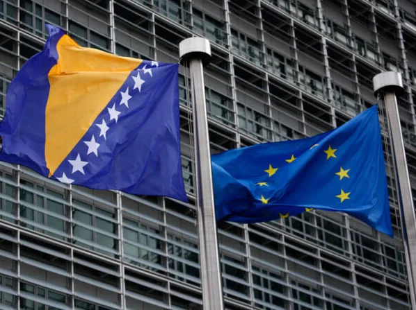 Zastave Bosne i Hercegovine i Evropske unije istaknute ispred moderne zgrade.