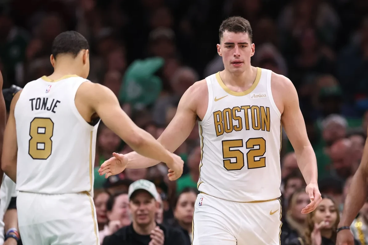 Košarkaši Boston Celticsa sa brojevima 52 i 8 na dresovima, rukuju se na terenu.