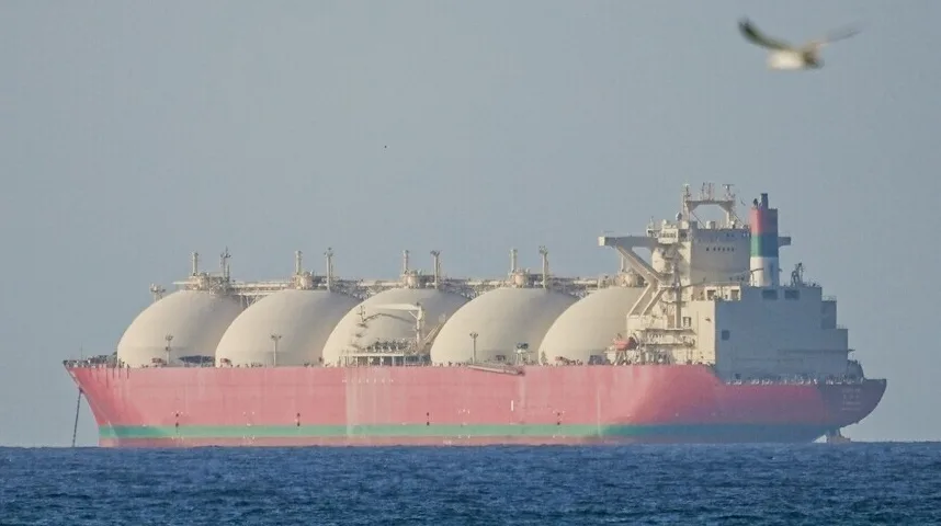 Veliki brod za prevoz tečnog naftnog gasa (LNG) sa pet vidljivih kuglastih rezervoara na palubi, plovi po mirnom plavom moru pod vedrim nebom.