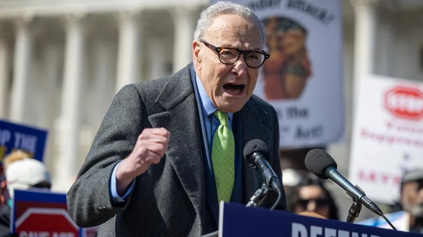 Chuck Schumer govori u mikrofon sa podignutom pesnicom.