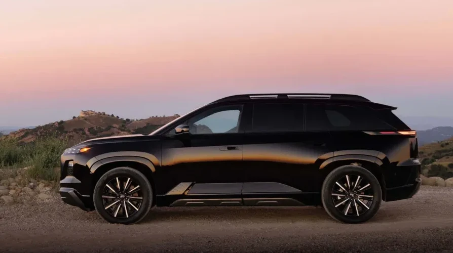 Crni luksuzni SUV parkiran na makadamskom putu uz brda u zalasku sunca