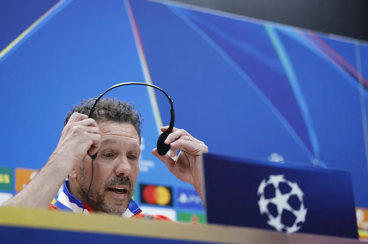 Diego Simeone, trener Atletica iz Madrida, stavlja slušalice na glavu tokom konferencije za medije.