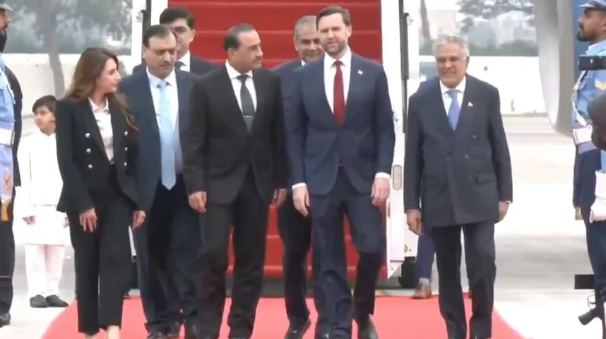 Grupa diplomata u odijelima i sa kravatama silazi niz crveni tepih sa stepenica aviona.