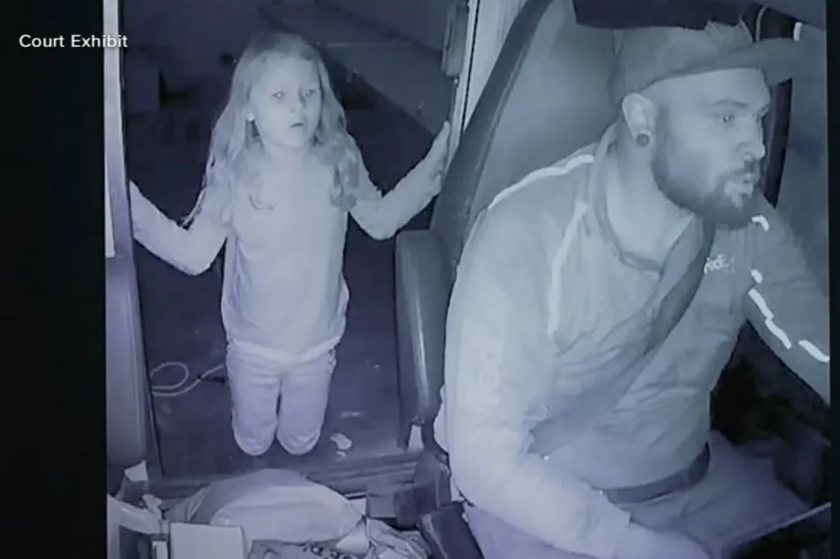 Snimak nadzorne kamere prikazuje malu djevojčicu sa plavom kosom kako stoji u kamionu pored vozača u Fedex uniformi.