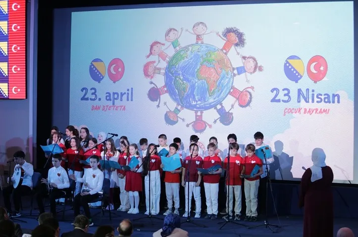 Djeca pjevaju na bini pred ekranom na kojem piše '23. april Dan djeteta' i '23 Nisan Çocuk Bayramı'