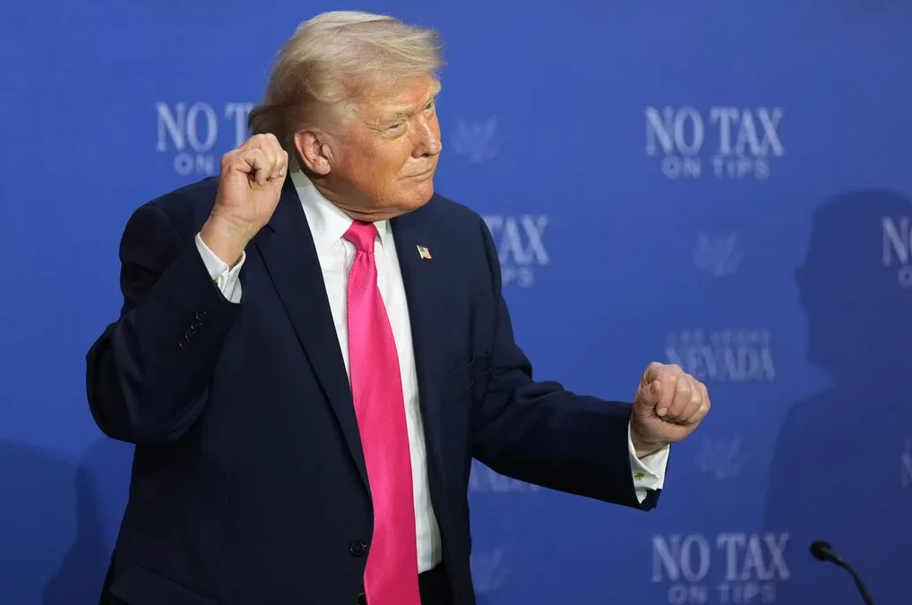 Donald Trump sa podignutom pesnicom i ružičastom kravatom