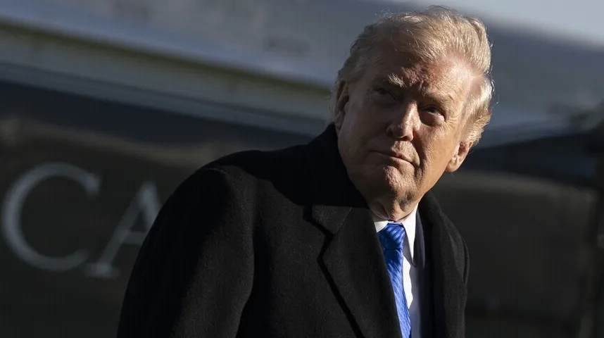 Donald Trump u crnom kaputu sa plavom kravatom