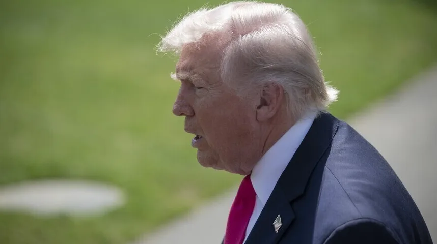 Donald Trump u tamnom odijelu i roze kravati, gleda lijevo sa otvorenim ustima.