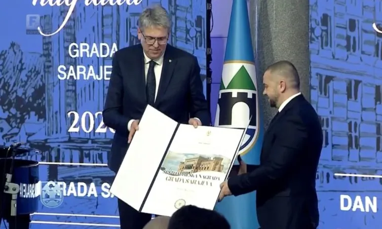 Dva muškarca u odijelima primaju Povelju/Nagradu Grada Sarajeva.