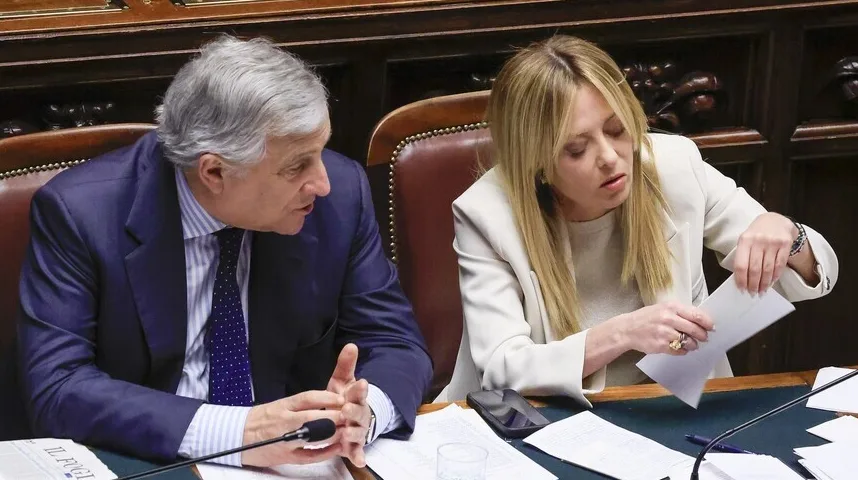 Muškarac i žena sjede za stolom u parlamentarnoj sali.