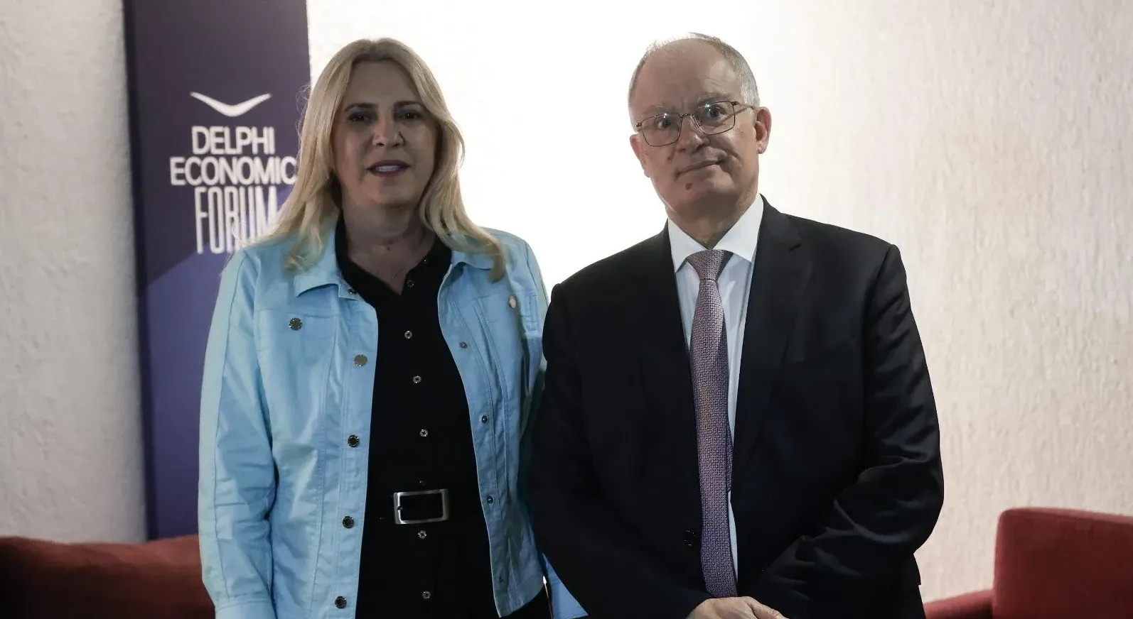 Žena i muškarac stoje pored natpisa "DELPHI ECONOMIC FORUM"