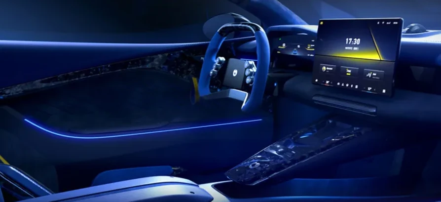 Futuristički enterijer automobila sa plavim ambijentalnim osvjetljenjem, velikim centralnim ekranom osjetljivim na dodir i modernim volanom.