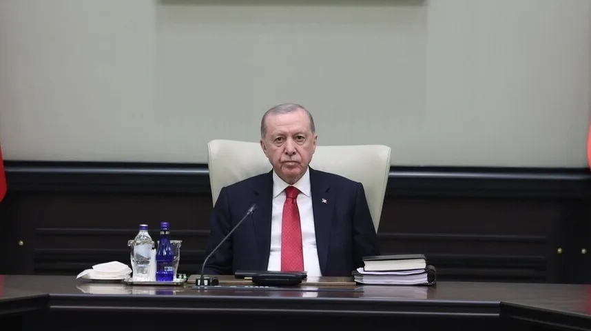 Recep Tayyip Erdoğan sjedi za stolom u uredskom prostoru.