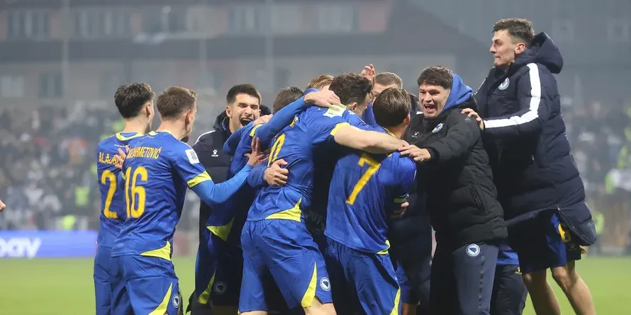 Fudbaleri Bosne i Hercegovine u plavim dresovima grle se i slave pobjedu na terenu.