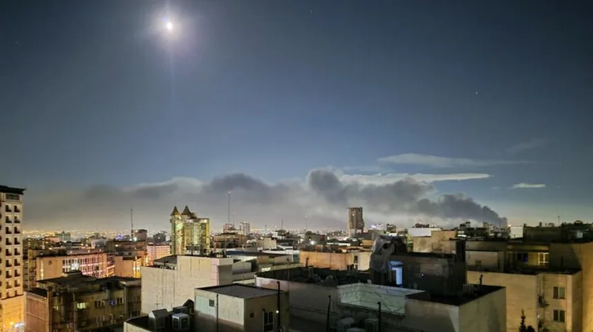 Gradski pejzaž noću sa gustim dimom iznad zgrada