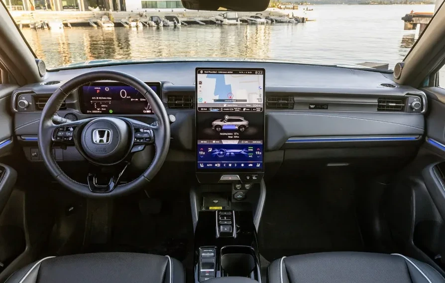 Unutrašnjost Honda e sa detaljnim prikazom digitalnog kokpita, centralnog infotainment ekrana sa navigacijom i prikazom stanja baterije.