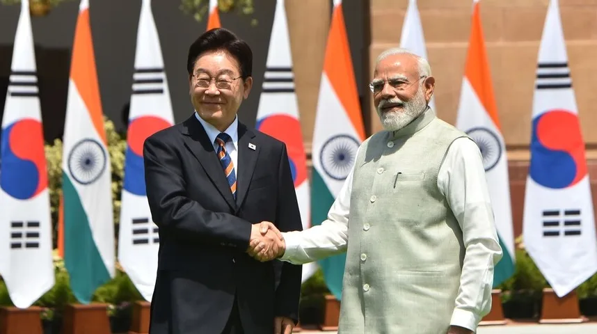 Narendra Modi i južnokorejski zvaničnik se rukuju ispred zastava dviju zemalja