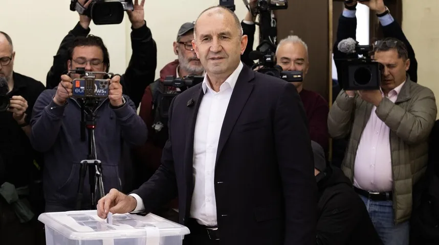 Predsjednik Bugarske, Rumen Radev, ubacuje glasački listić u kutiju dok ga okružuju novinari sa kamerama tokom izborne kampanje.