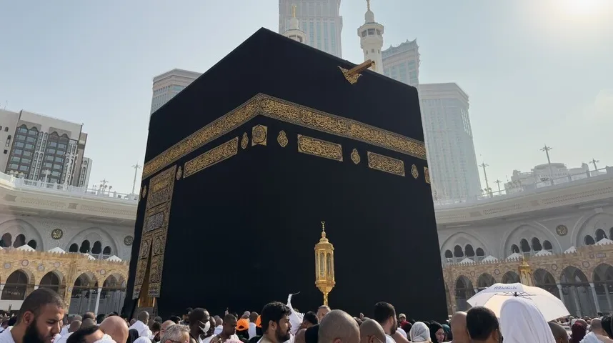 Pojedinac sa grupom ljudi u dvorištu Kabe, Saudijska Arabija.