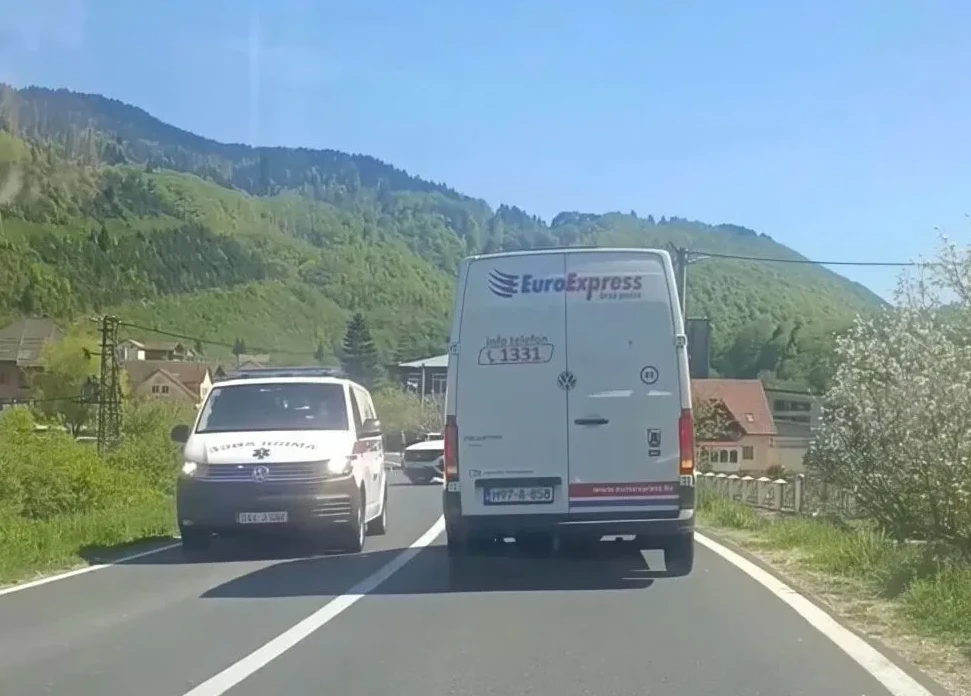 Kombi kompanije "EuroExpress" i vozilo hitne pomoći na putu kroz brdoviti predio.