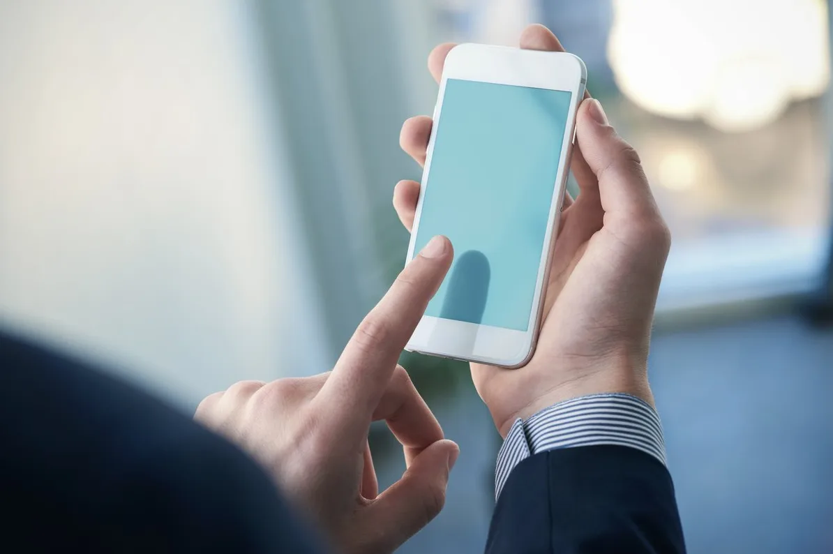 Bliski pogled na ruke koje drže i koriste pametni telefon