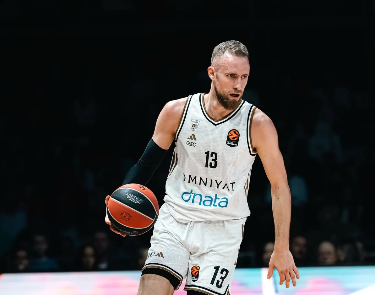 Košarkaš u bijelom dresu sa brojem 13 drži loptu u ruci.