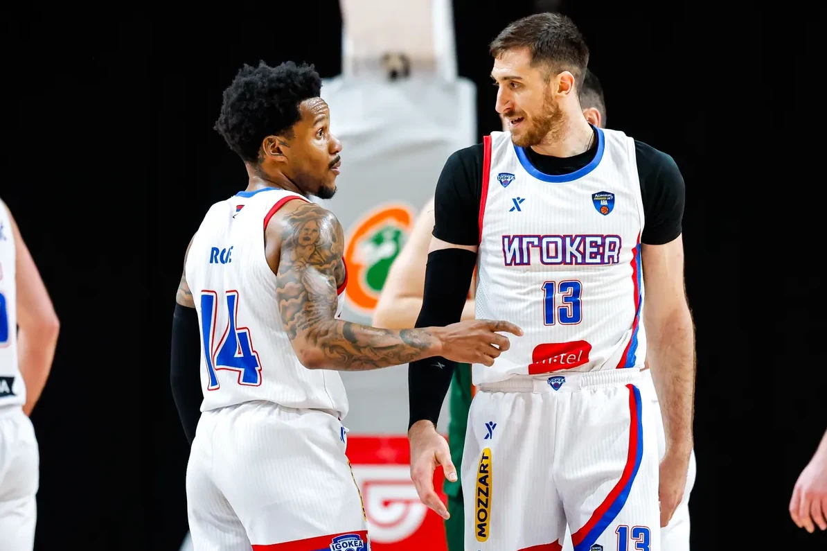 Dva košarkaša KK Igokea, jedan sa brojem 14, a drugi sa brojem 13 na dresu, razgovaraju na terenu.