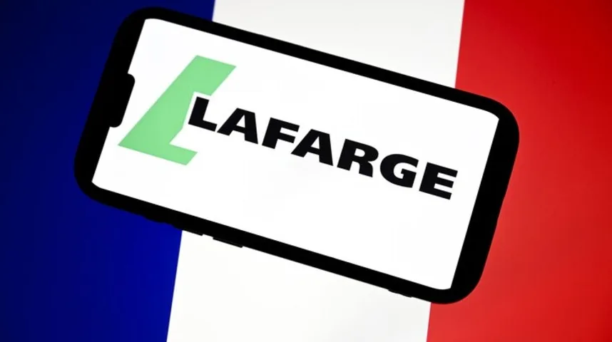 Logo Lafarge brenda na ekranu mobilnog telefona, postavljen iznad francuske zastave.